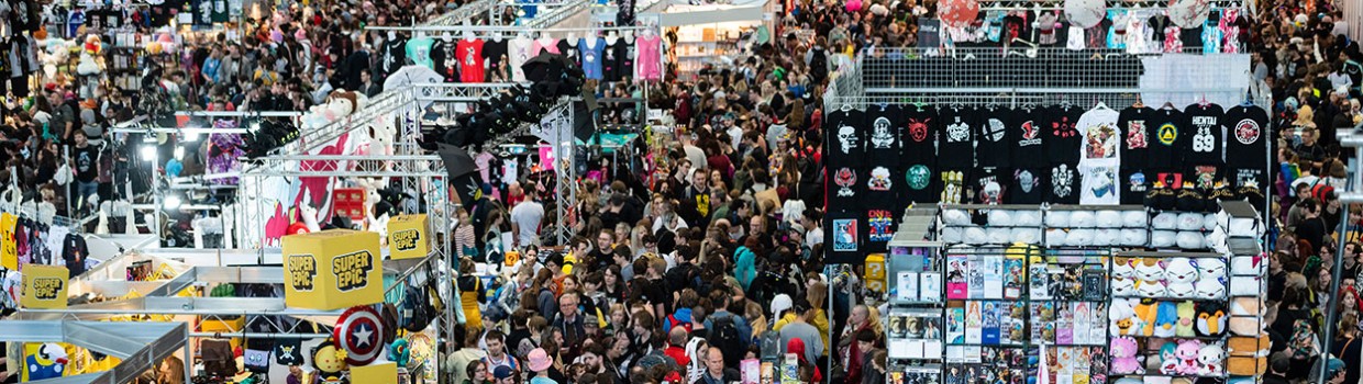 Aufnahme einer Halle auf der Manga-Comic-Con mit vielen Ständen und Besucher:innen