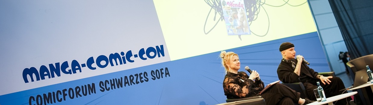 2 Personen auf der Bühne des Comicforum Schwarzes Sofa auf der Manga-Comic-Con 2025