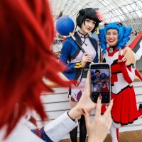 Cosplayer:in und Macoco in bunten Anime-Kostümen posieren lächelnd für ein Foto auf der Manga Comic Con 2025