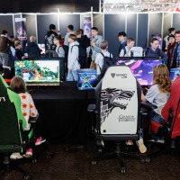 mehrere Personen spielen an Computern oder sehen sich um im Gamesroom der Manga-Comic-Con 2025