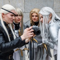 Vier Cosplayer:innen mit langen weißen Perücken schauen gemeinsam auf eine Kamera bei der Manga Comic Con 2025