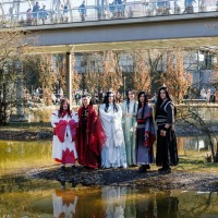 Gruppe von Cosplayer:innen posieren vor der Glashalle der Manga Comic Con 2025