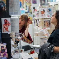 Künstlerstand mit Besucher:innen in der New Artist Alley auf der Manga-Comic-Con 2025