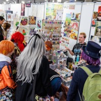 Künstlerstand mit Besucher:innen in der New Artist Alley auf der Manga-Comic-Con 2025